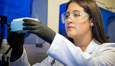 Researcher holding a tray of test tubes at eye level.