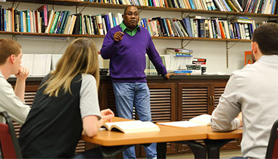 Professor talking with a table of students.