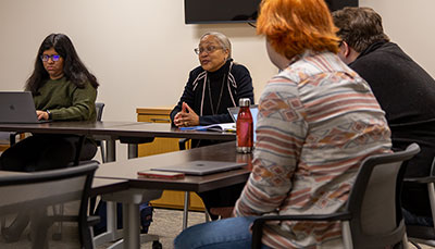 Small class at a table having a discussion.