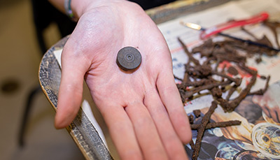 Small artifact laying in the palm of a hand.