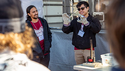Person giving a physics demonstration.