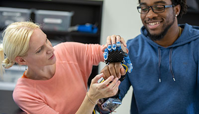 Two students examining a device.