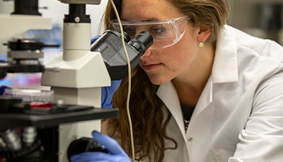 Student looking through a microscope. 