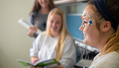 Students testing out a device attached to one's face.