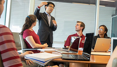 Professor talking to a table of students.