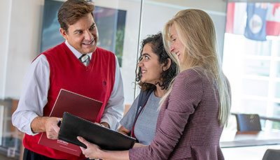 Professor looking over a report with two business students.