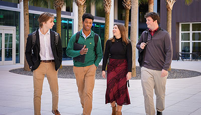 Group of business student standing outside in the courtyard at the Moore School.