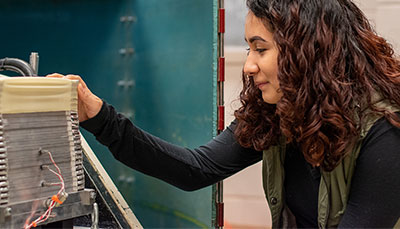 Student working with a piece of equipment in an engineering lab.