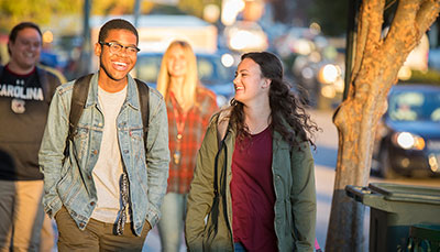 Two students walking on sidewalk in downtown Columbia, SC.