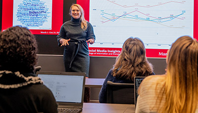 Faculty member at the front of the classroom teaching to students.