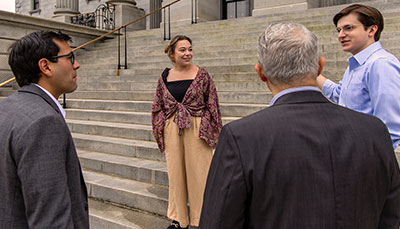 Group of people standing on the statehouse steps. 