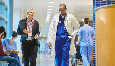 Doctor walking with a lawyer in a lobby.