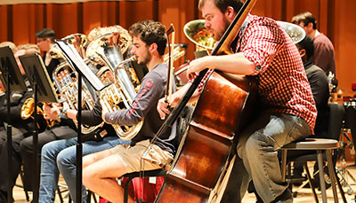 Line of tubas playing at practice. 
