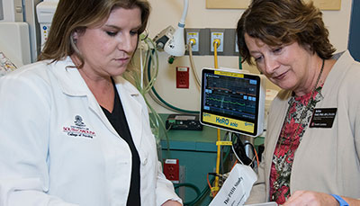 Two nurses looking at a chart together. 