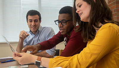 Three people talking at a table.
